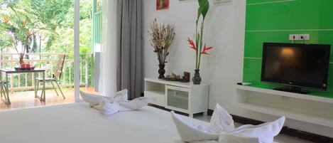 Habitación de hotel con una cama grande, televisión, escritorio y vistas al exterior.