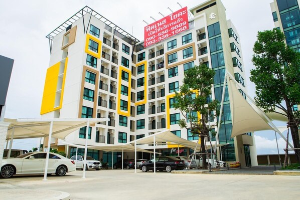 A multi-story hotel with a modern design, featuring balconies and a prominent yellow and white color scheme.