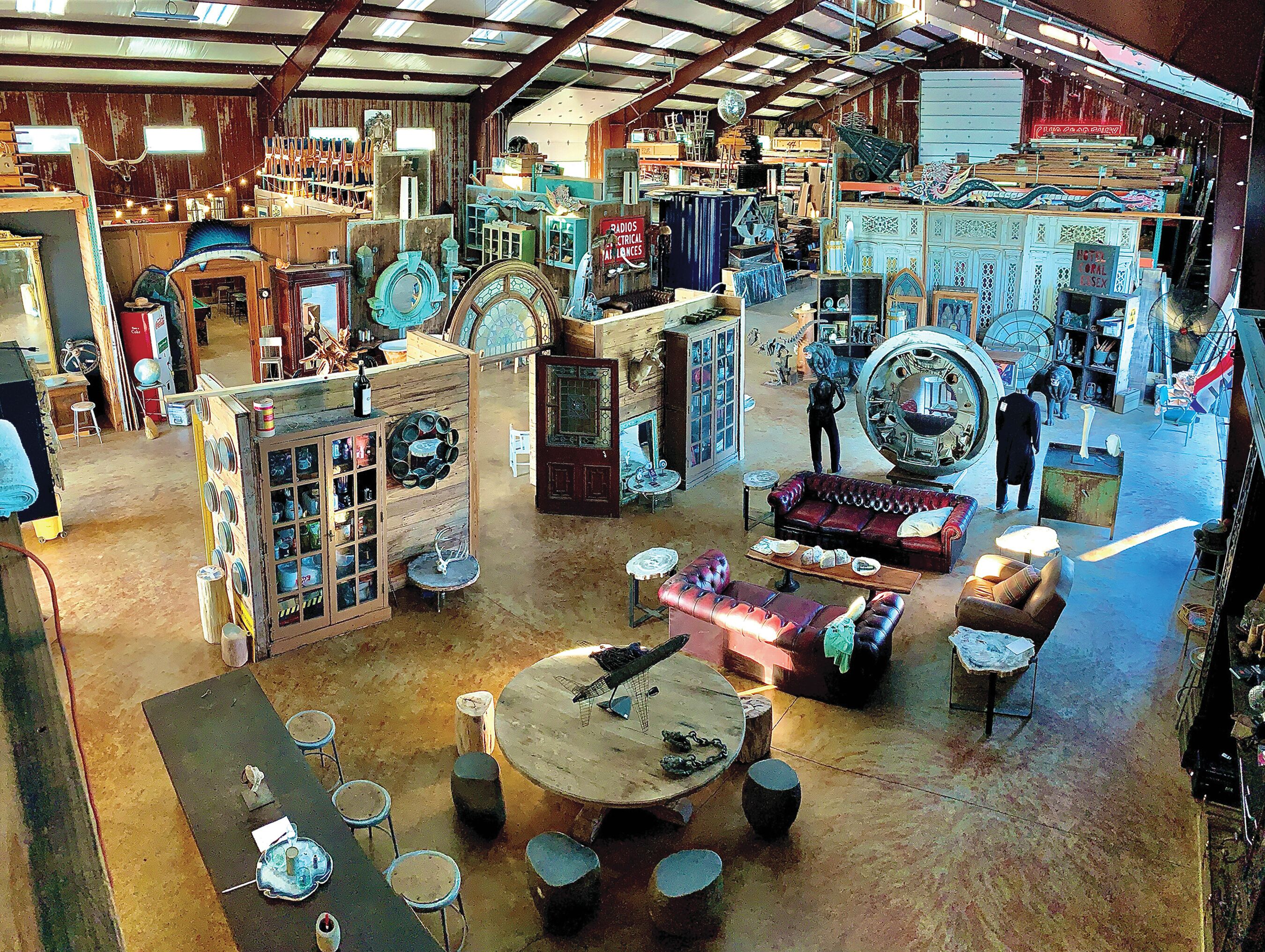 A spacious antique shop with various furniture and decorative items.