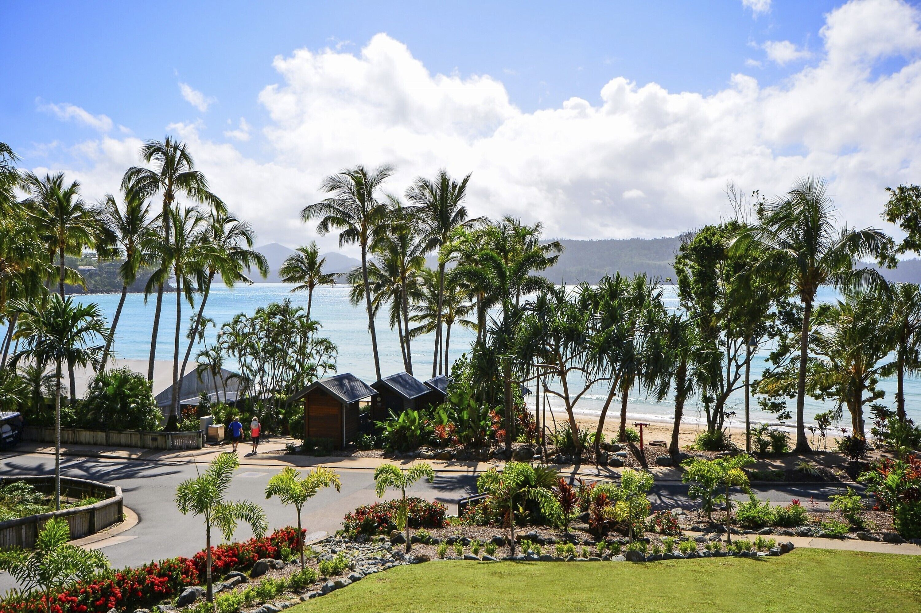 Ein Resort mit Palmen, einem Strand und blauem Himmel.