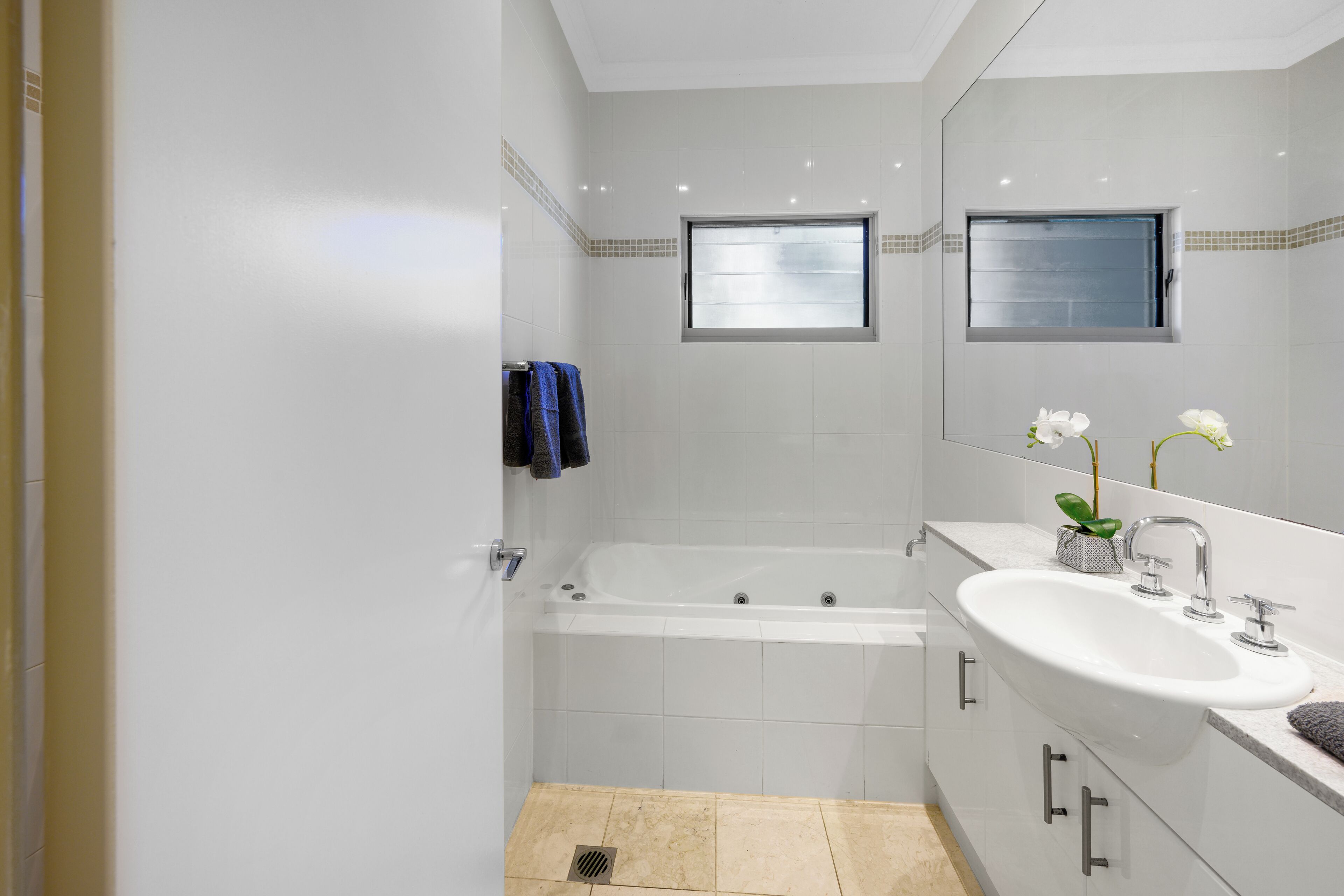 A modern bathroom with a bathtub, a sink, and a mirror.