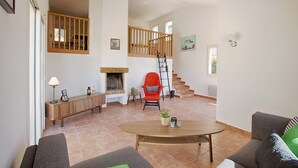 A spacious living room with a fireplace, a staircase, and a dining area. - Impressive villa overlooking the hill (Joyeuse)