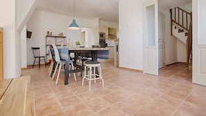 A spacious kitchen with a dining area, a staircase, and a view of the living room. - Impressive villa overlooking the hill (Joyeuse)