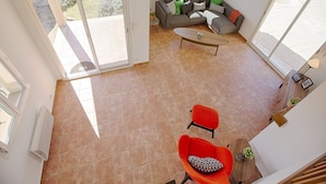 A spacious living area with a sofa, a coffee table, and two chairs. There are large windows providing natural light and a view of the outdoors. - Impressive villa overlooking the hill (Joyeuse)