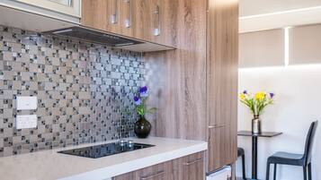A modern kitchen with wooden cabinets, a built-in microwave, and a tiled backsplash.