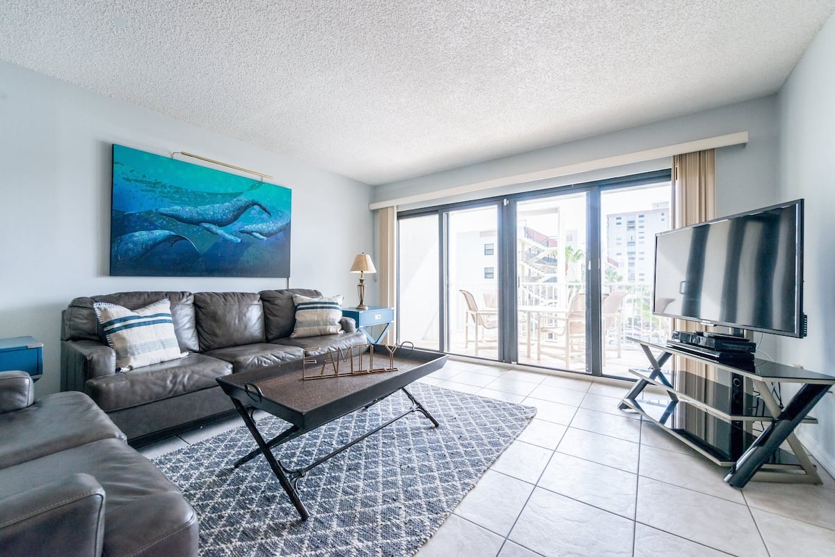 A modern living room with a sofa, coffee table, and TV stand.