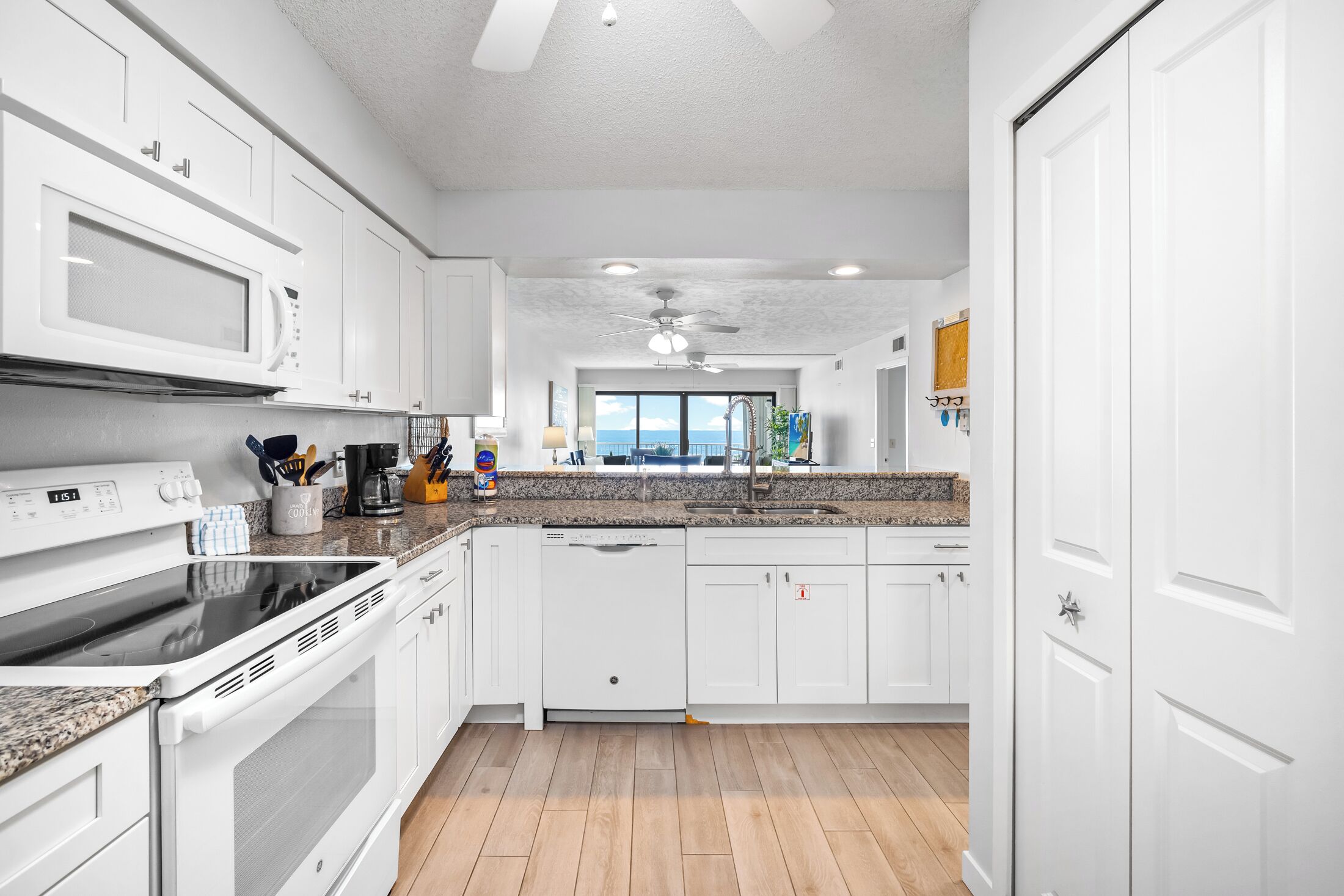 A modern kitchen with white cabinetry, a built-in microwave, and a dishwasher.