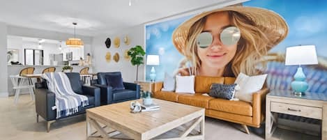 A modern living room with a large sofa, a coffee table, and a dining area with chairs.