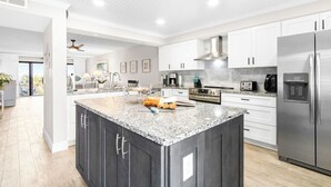 A modern kitchen with granite countertops, stainless steel appliances, and a large island. - Sandcastles - Cocoa Beach Oceanfront Condos with Heated Pool Tennis Pet-Friendly (Cocoa Beach)