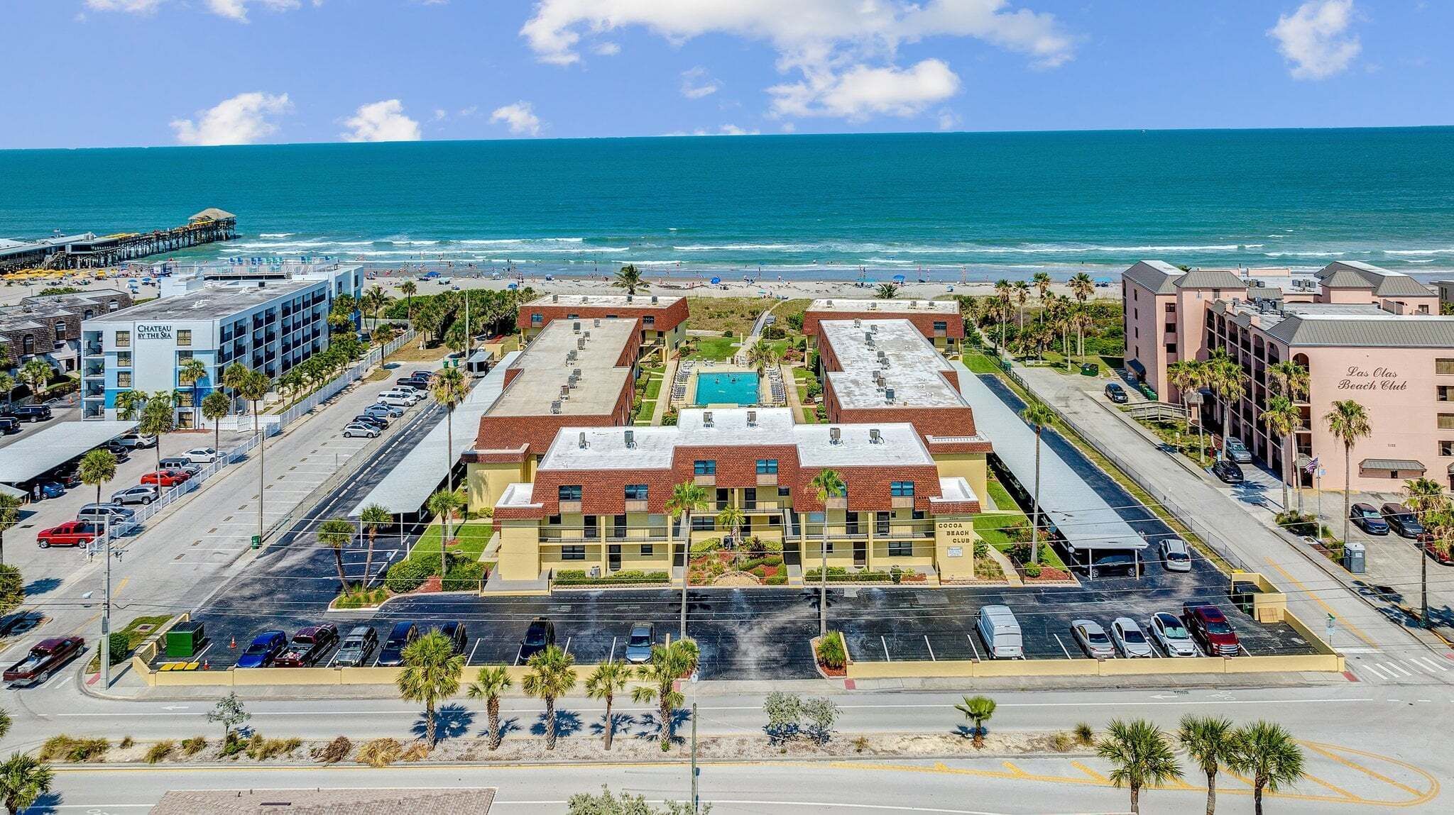Ein Hotel mit Innenhof, Pool und Blick auf den Strand.