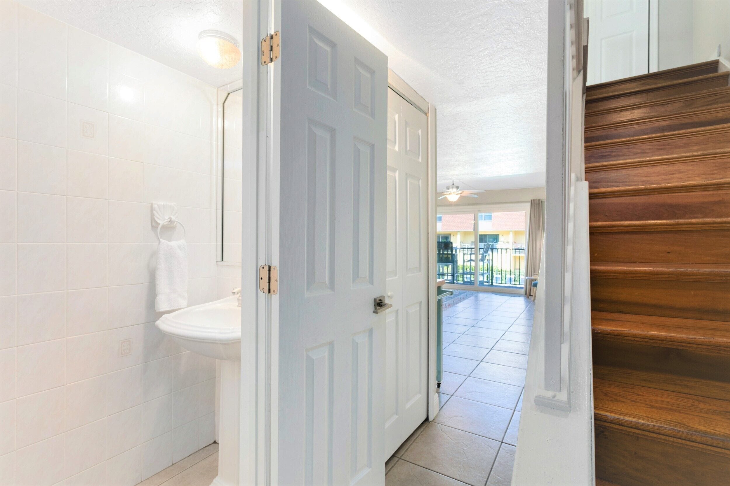 A bathroom with a white toilet, a sink, and a towel hanging on the wall.