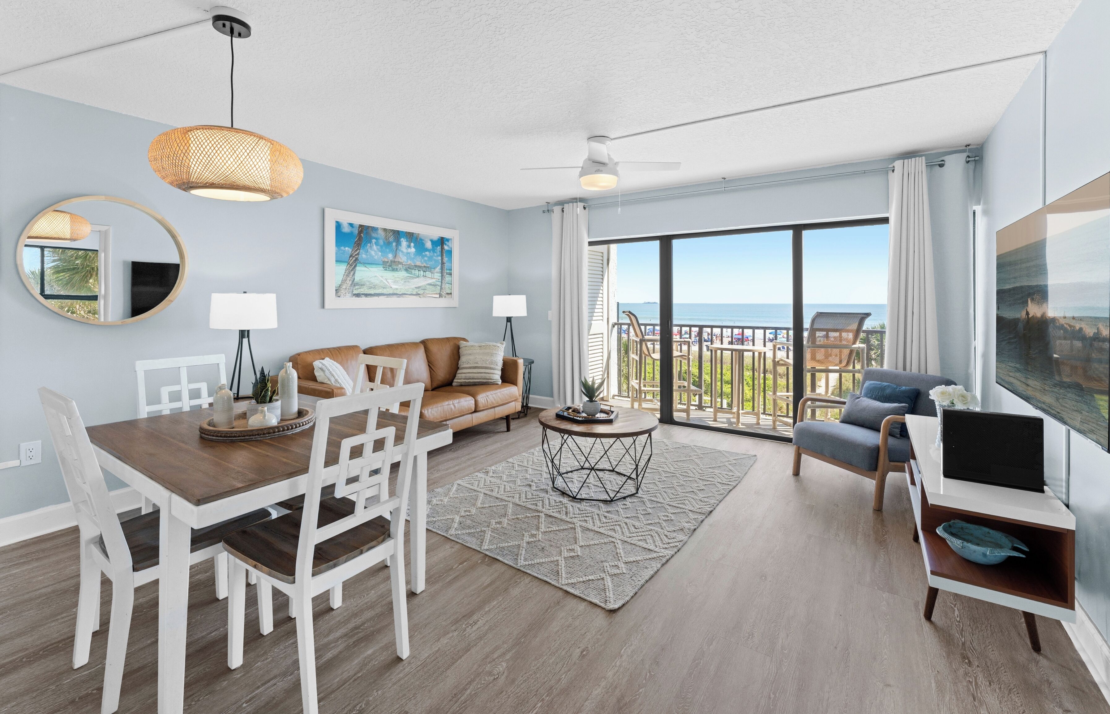 Un salon moderne comprenant un coin repas, un canapé, un téléviseur et un balcon avec vue.