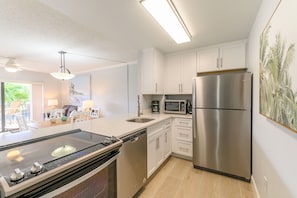 Enjoy cooking in this well-lit kitchen with a large island, stovetop, and modern appliances.