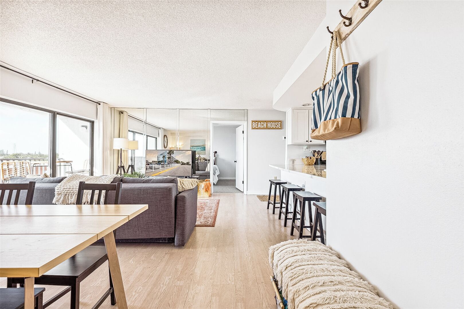 A modern living room with a sofa, dining table, and kitchen area.