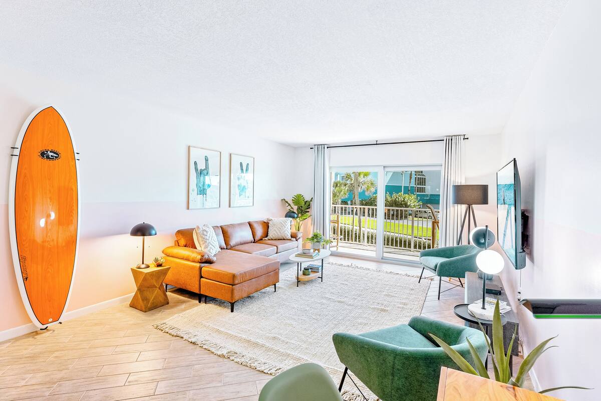 En moderne stue med en stor surfbræt, sofa, sofabord og tv.