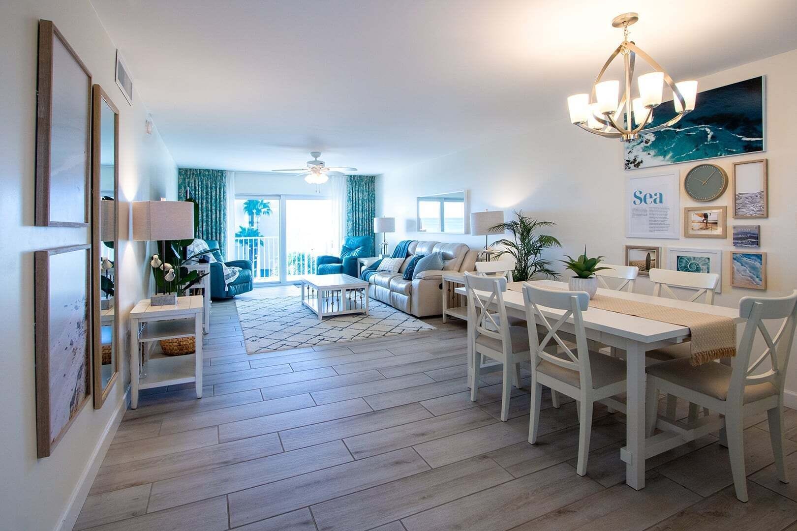 A spacious living area with a dining table, sofas, and a view to the outside.