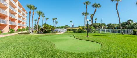 A golf course with a building on one side.
