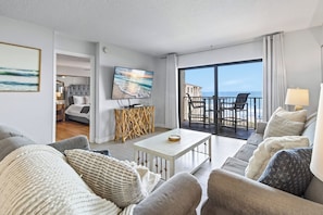 Une chambre d’hôtel moderne dotée d’un balcon, d’une télévision et d’un coin repas.