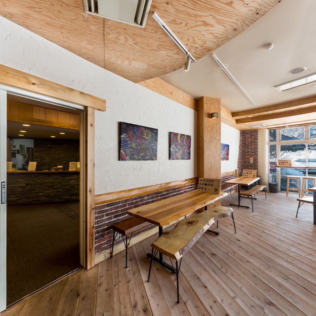 A modern interior with wooden floors, a brick accent wall, and a long bench seating area.