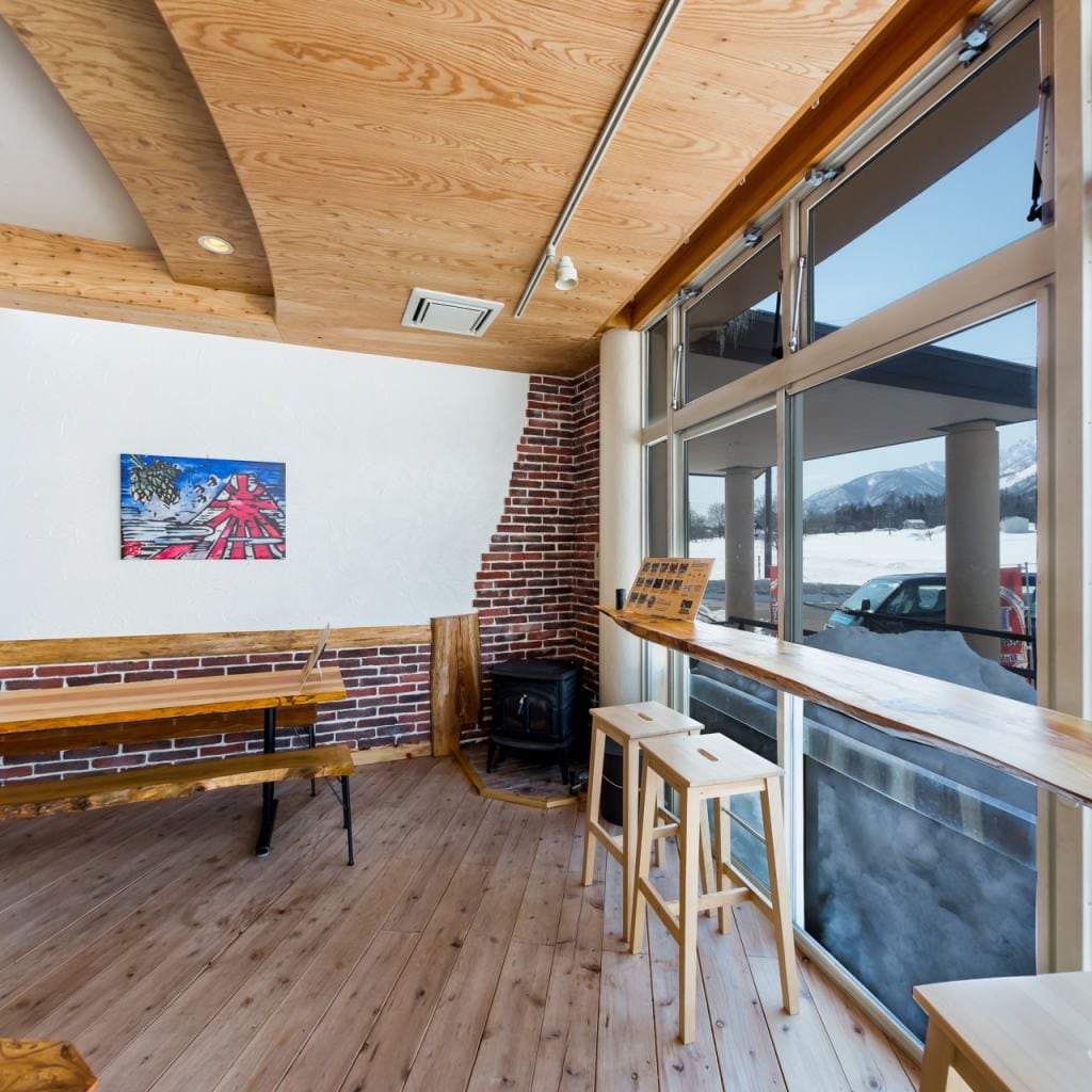 Un interior acogedor con pisos de madera, pared de ladrillo y un ventanal con vistas al exterior.