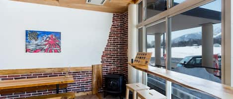 Un interior acogedor con pisos de madera, pared de ladrillo y un ventanal con vistas al exterior.