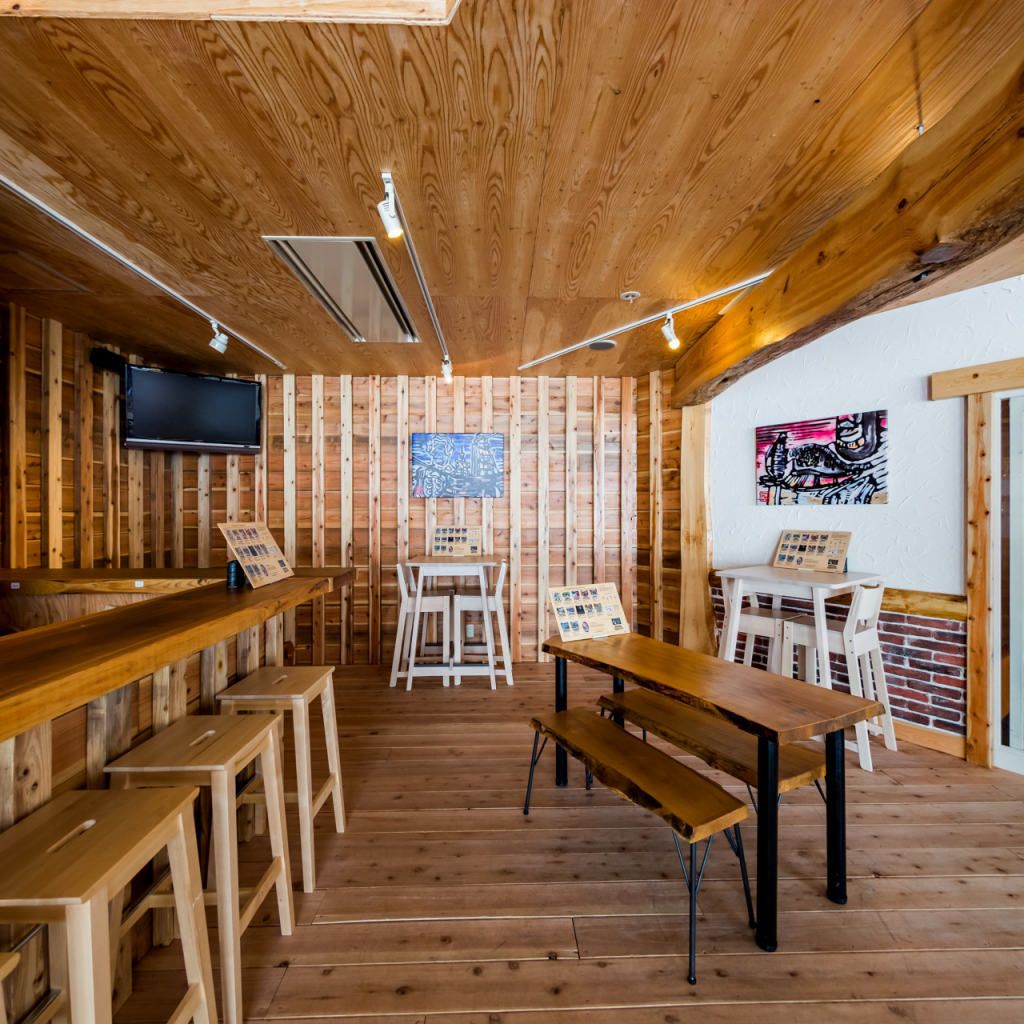 A rustic wooden interior with a bar area, seating, and artwork on the walls.