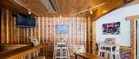 A rustic wooden interior with a bar area, seating, and artwork on the walls.