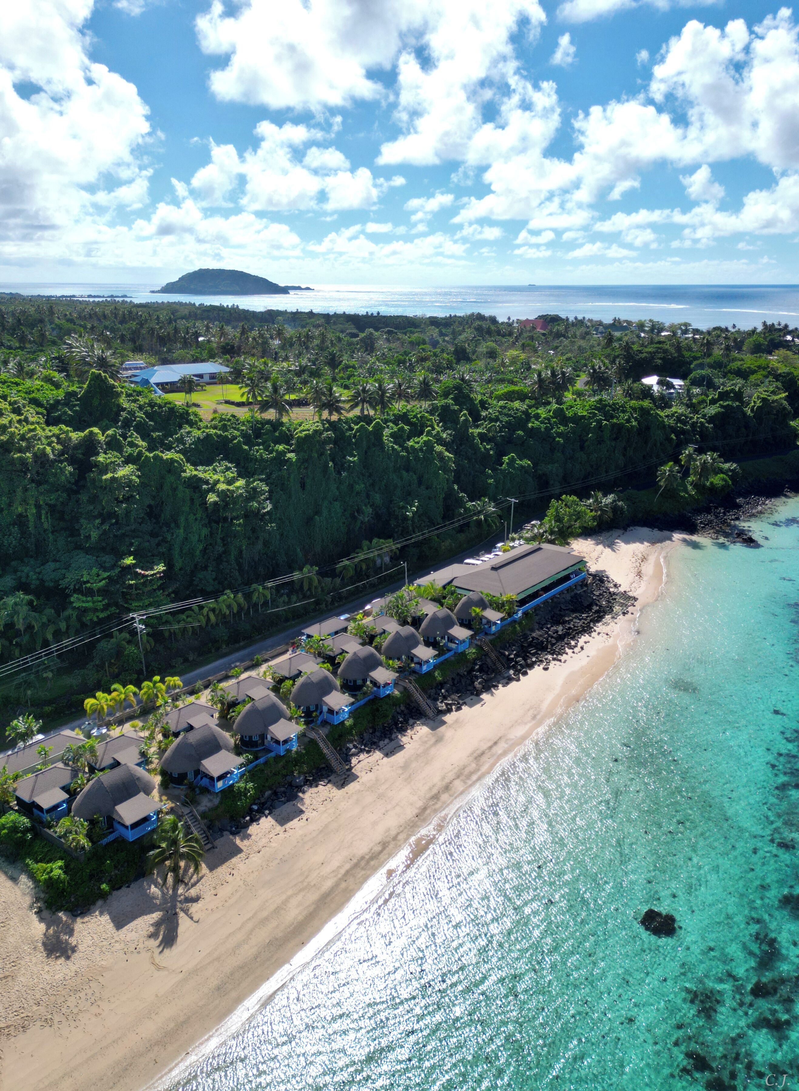 A beachfront resort with overwater bungalows, clear turquoise waters, and lush greenery.