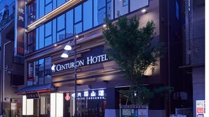 A modern hotel building with a prominent sign for the Centurion Hotel.