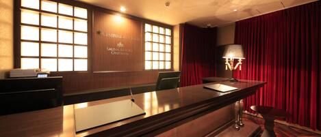 Una recepción con detalles de madera, un reloj digital y un cartel para Centurion Hotel Sauna Resort Oriental.