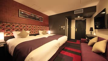 Habitación de hotel con una cama grande, un escritorio, una silla y un televisor.