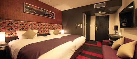 A hotel room with a large bed, a desk, a chair, and a TV.