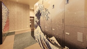 A hallway with lockers and a mural of waves on the wall.