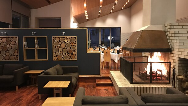 Un espacio lounge moderno con sofás, mesas y chimenea.