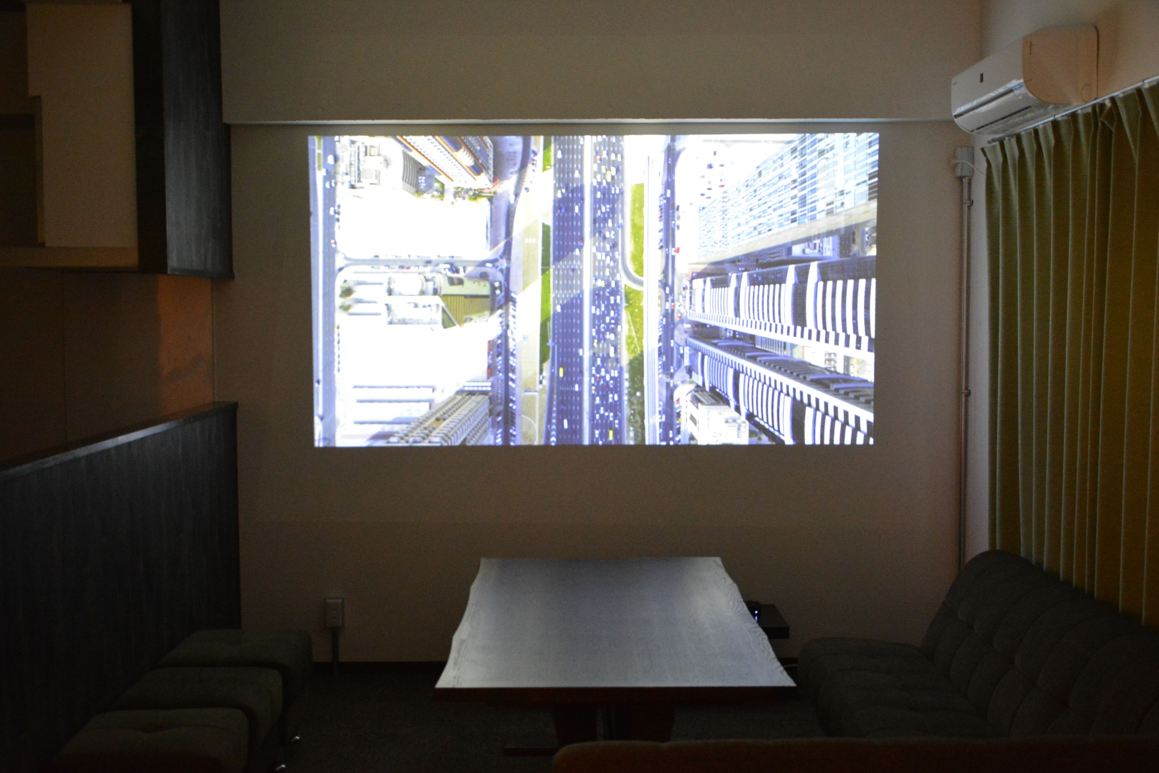 A room with a large window, a table, and a couch.