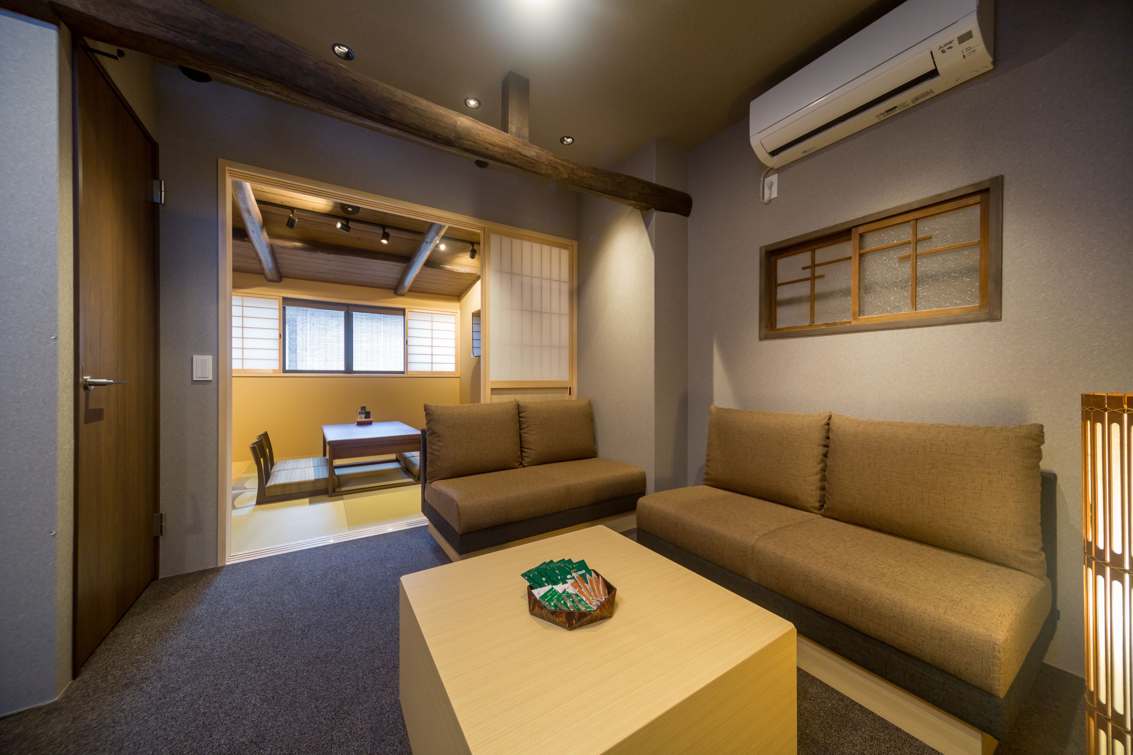 A compact living space with a sofa, a small table, and a traditional Japanese sliding door.