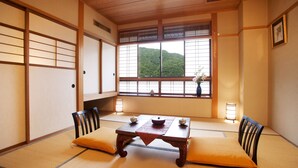 A traditional Japanese room with tatami flooring, a low wooden table, and cushions. - Hirayuonsen Yamatokan (Takayama)
