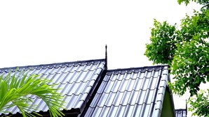 A traditional building with a tiled roof, a covered porch, and lush greenery surrounding it. - Sawasdee Sukhothai Resort (Sukhothai)