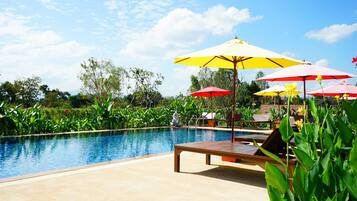 A pool area with lounge chairs and umbrellas.