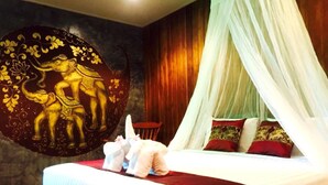 A bed with a canopy, a wall with a decorative mural, and a wooden chair. - Sawasdee Sukhothai Resort (Sukhothai)