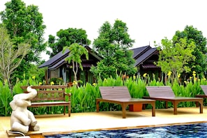 Una piscina al aire libre, sombrillas, tumbonas