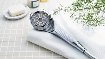 Un pommeau de douche au design moderne, posé sur une serviette blanche.