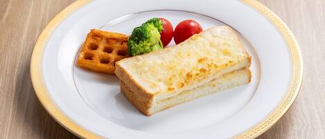 Un plato con un gofre, una rebanada de queso y un trozo de brócoli.