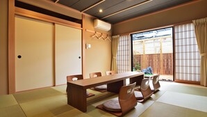 Una habitación japonesa tradicional con suelo de tatami, una mesa de madera y puertas correderas.