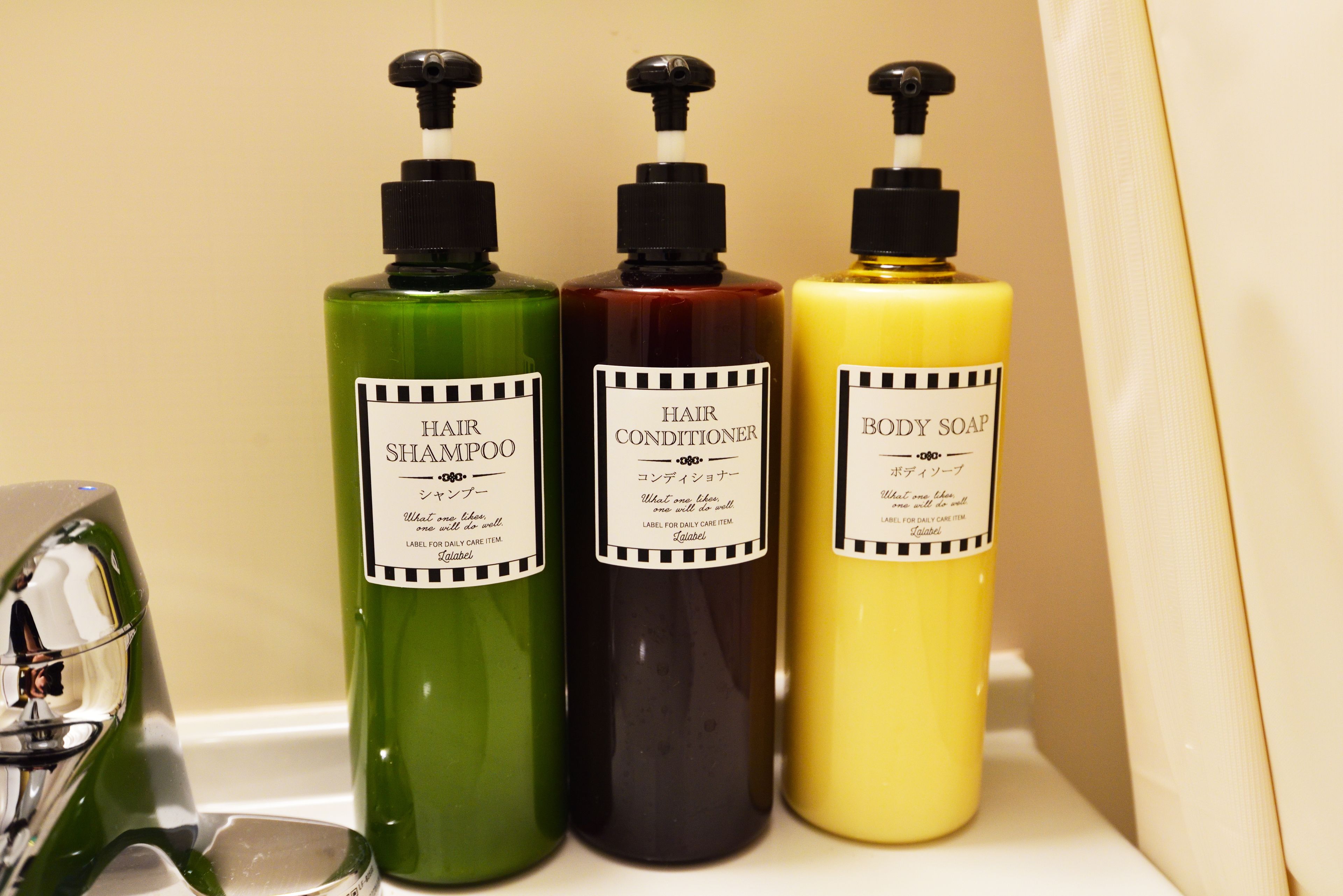 Three bottles of hair care products on a shelf.