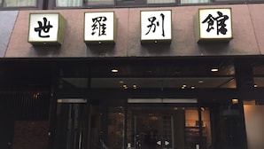 Un bâtiment sur lequel sont fixées quatre enseignes lumineuses au-dessus de l’entrée, chacune affichant des caractères chinois.