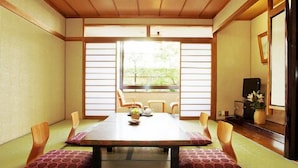 Une pièce de style japonais traditionnel, avec un sol recouvert de tatamis, une table basse avec des coussins et des portes coulissantes en papier de riz (shoji).