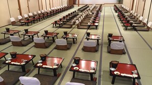 Une pièce de style japonais traditionnel, avec un sol recouvert de tatamis, de petites tables basses et des coussins.