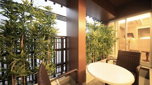 A balcony with a table and chairs, surrounded by bamboo plants. - The Centurion Hotel Classic Akasaka (Tokyo)