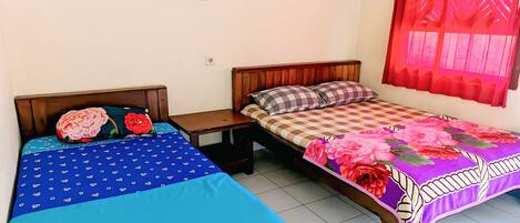 A room with two beds, each with a distinct patterned bedspread.